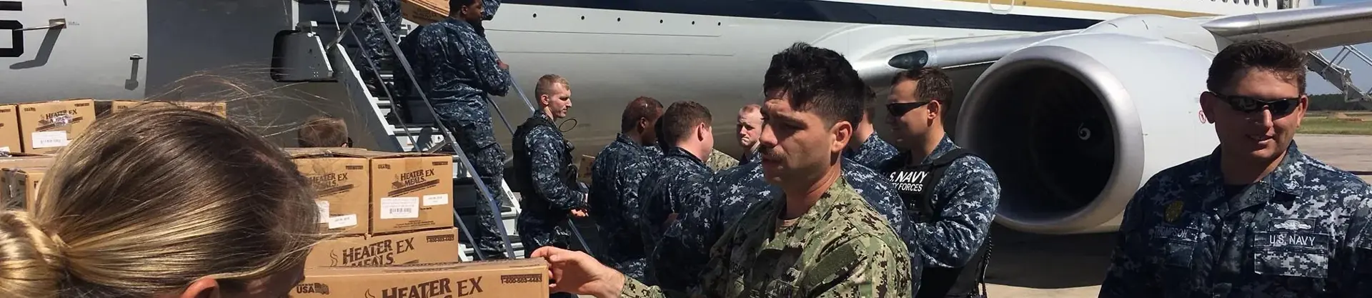 Soldiers moving boxes in front of plane
